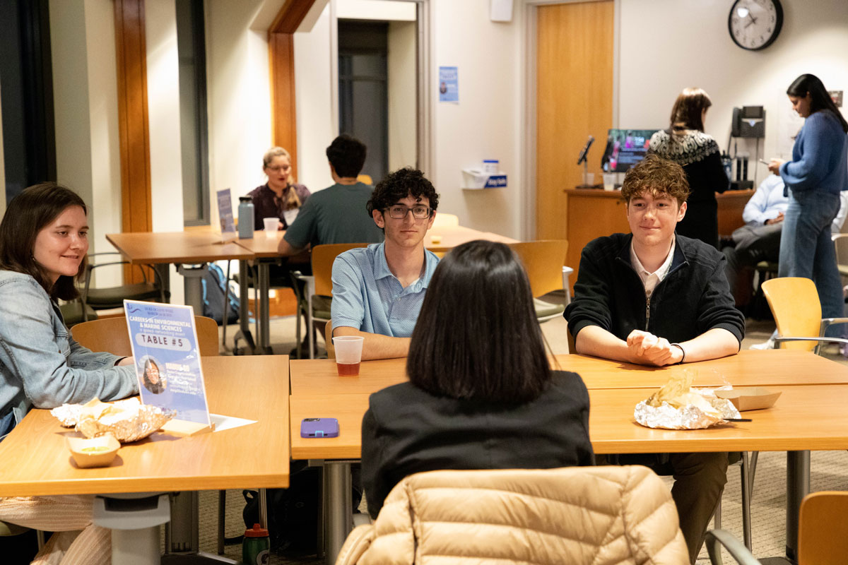 Four students seated at a table for a speed networking event